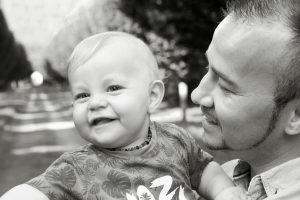 Vater mit Kind vor Baumallee fotografiert