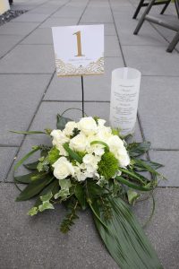 Weißer Blumestrauß zur Hochzeit mit goldener Tischnummer und Menükarte